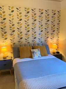 a bedroom with a blue bed with two lamps at The Briars in Paignton