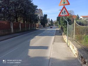 an empty street with a caution sign on a fence at Studio apartman Lea in Pula