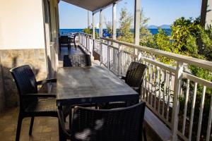 a table and chairs on a balcony with the ocean at House Kohili in Nea Vrasna