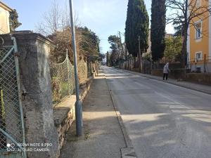 a woman walking down a street next to a fence at Studio apartman Lea in Pula +33 photos