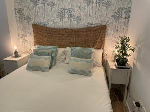 sypialnia z białym łóżkiem i białymi poduszkami w obiekcie Cozy Loft Malaga Centre II w Maladze