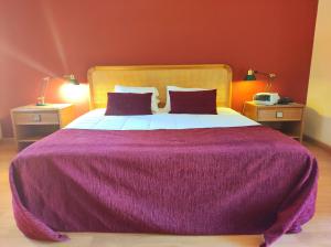 Ribeirotel في البرغاريا-ا-فلهه: غرفة نوم بسرير ارجواني كبير مع مصباحين
