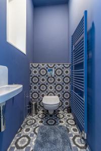 a blue bathroom with a toilet and a sink at Stylish luxury flat in Old Town in Staré Mesto