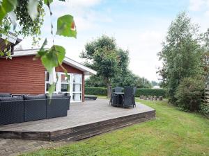 un patio avec deux chaises et un canapé sur une terrasse dans l'établissement 10 person holiday home in Juelsminde, à Juelsminde
