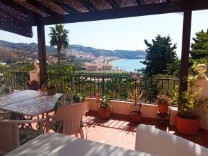balcón con mesa, sillas y vistas al océano en Valle y Mar, Casa de Huéspedes en La Herradura