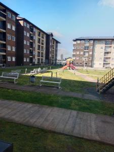 a park with benches and a playground in front of buildings at Departamento familiar en Osorno in Osorno