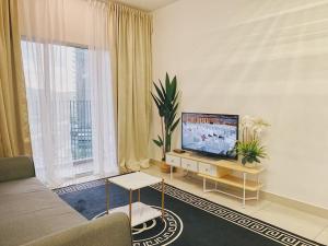 uma sala de estar com uma televisão de ecrã plano e um sofá em Sofia Homestay Cerrado Southville City Bangi Netflix Wifi em Kampong Tangkas