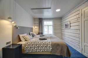 1 dormitorio con 1 cama con pared de madera en Tõstamaa Meierei Hotel, en Tõstamaa