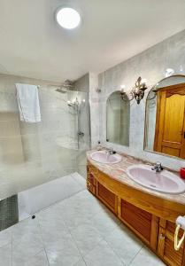 W łazience znajdują się 2 umywalki, prysznic i lustro. w obiekcie Precioso apartamento con vistas en la Herradura w mieście La Herradura