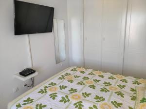 a bedroom with a bed with a television on the wall at Casas Holiday - Golf Campoamor in Orihuela Costa