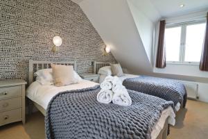a bedroom with two twin beds with towels on the bed at Contemporary beachside apartment in St Merryn