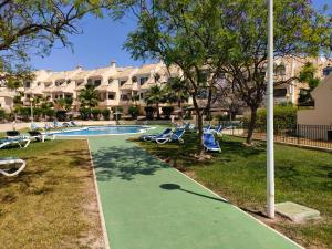 a swimming pool with lounge chairs and a resort at Casas Holiday - Golf Campoamor in Orihuela Costa
