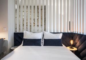 a bedroom with a large bed with two pillows at ORM - Mártires & Pinheiro Apartments in Porto