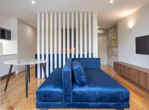 ein blaues Sofa im Wohnzimmer mit einem Tisch in der Unterkunft ORM - Mártires & Pinheiro Apartments in Porto