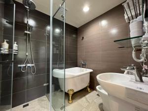 La salle de bains est pourvue d'une douche, d'une baignoire et d'un lavabo. dans l'établissement 旅途中海邊民宿, à Sanzhi