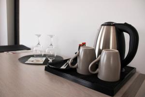 a tea kettle and two mugs on a tray on a table at Hotel Brotnjo in Čitluk