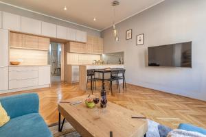 een keuken en een woonkamer met een tafel en een bank bij Stylish luxury flat in Old Town in Staré Mesto