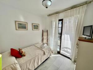 sypialnia z łóżkiem, telewizorem i oknem w obiekcie Precioso apartamento con vistas en la Herradura w mieście La Herradura