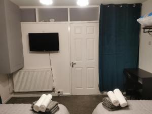 a room with a tv and a bed with towels at 116 maison dieu Road room B in Dover in Dover