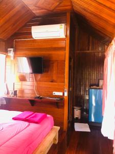 sypialnia z łóżkiem i telewizorem na ścianie w obiekcie KOB SUK RESORT k7 , k10 w mieście Sichon