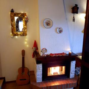 La casa del Cucù al Ravascletto, 900mt from cable car في رافاسكليتو: غرفة معيشة بها موقد و غيتار