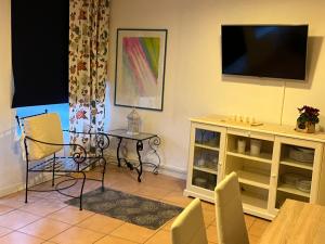 ein Wohnzimmer mit einem Tisch und einem TV in der Unterkunft Da Esterina appartamento sulla riviera del Brenta in Mira