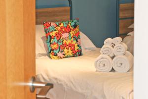 a bed with towels on it with a pillow at STYLISH, BEACHSIDE apartment, sea views in St Merryn