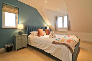 a bedroom with a bed with two stuffed animals on it at STYLISH, BEACHSIDE apartment, sea views in St Merryn