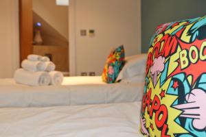 a hotel room with two beds with towels on them at STYLISH, BEACHSIDE apartment, sea views in St Merryn +10 photos