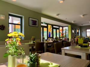 a restaurant with tables and chairs and windows at Villa Frieden Hotel & Seminarhaus in Bad Blankenburg