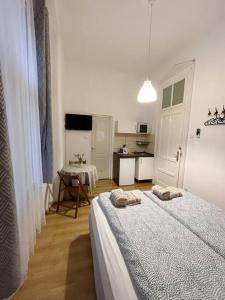 Habitación blanca con 2 camas y mesa en 12# Sunflower Cozy Apartment en Budapest