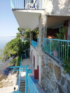 a house on the beach with blue stairs at Locazione Turistica Sul Mare Strada Costiera 244, Trieste in Santa Croce Mare