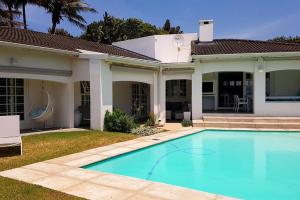 a house with a swimming pool in the yard at Magnificent beach house with stunning ocean views! in Zinkwazi Beach