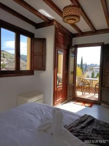 a bedroom with a bed and a view of a patio at Nasrid Generalife - Carmen con patio ajardinado y vistas panorámicas in Granada