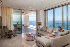 a woman sitting on a couch in a living room at Four Seasons Hotel in Limassol