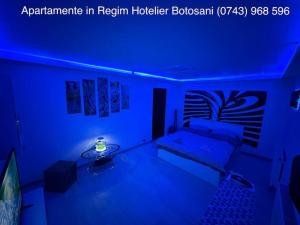 une chambre bleue avec un canapé et une table dans l'établissement Apartament cu 2 camere/Curte privata/La parter/Lux oferim factura, à Botoşani