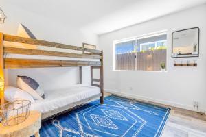 een slaapkamer met 2 stapelbedden en een blauw tapijt bij Howdy Amigos Surf Getaway in San Clemente +12 foto's