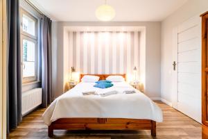ソポトにあるVictus Apartamenty, Villa Haffneraのベッドルーム1室(白いシーツと青い枕のベッド1台付)