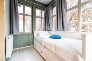 a bedroom with a bed and two windows at Victus Apartamenty, Villa Haffnera in Sopot