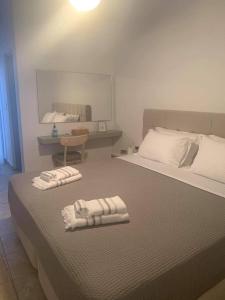 een slaapkamer met een bed met twee handdoeken erop bij La Main Street suite in Andiparos
