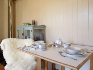 a table with cups and saucers on it at Molly The Shepherds Hut in Bampton