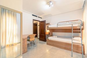 um quarto com beliches, uma secretária e um espelho. em Green- Apartments Las Setas em Sevilha