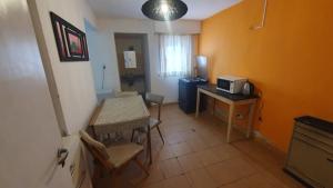 Mały pokój ze stołem i kuchenką mikrofalową w obiekcie Habitacion economica con estacionamiento Necochea w mieście Necochea
