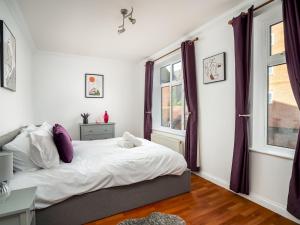um quarto com uma cama e duas janelas em Pass the Keys Stylish Cosy and Central 1 Bed Flat with Parking em Rickmansworth