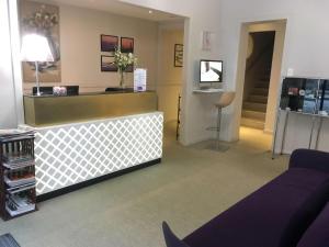 uma sala de espera com um balcão e uma televisão em Hotel Le Sevigne - Sure Hotel Collection by Best Western em Rennes