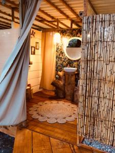 a bathroom with a wooden floor with a door open at Glamping - La Casa del Piano in Chiclana de la Frontera