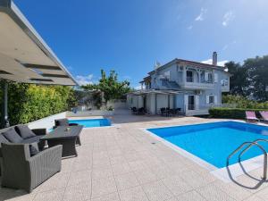 un patio trasero con piscina y una casa en Friends and Family House, en Petalidi