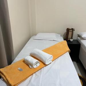 Dos toallas en una cama en una habitación en HOSTEL GIRASSOL en Ponte Alta do Tocantins