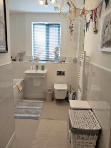 bagno bianco con lavandino e servizi igienici di Stunning Apartment with Private Beach & Balconies a Charlestown