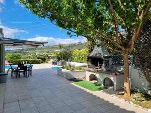 a patio with a grill and a table and chairs at Friends and Family House in Petalidhion